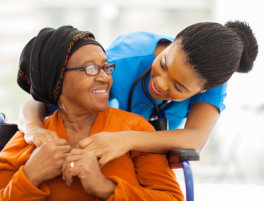 A nurse assists an elderly woman in a wheelchair