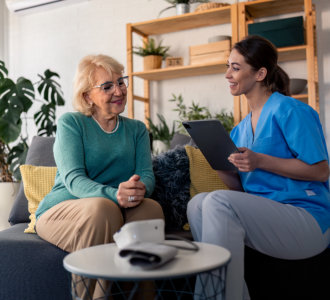 aide and senior woman having a conversation and smiling