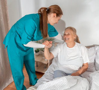 aide smiling while taking care of the senior woman