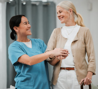 aide and senior woman smiling at each other