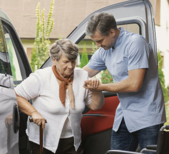 aide assisting the senior woman to walk