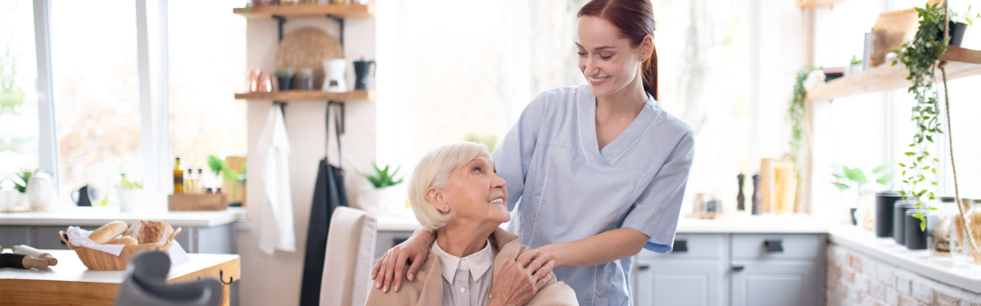 carer and senior woman smiling at each other