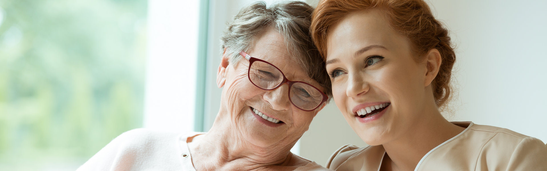 carer and senior woman smiling