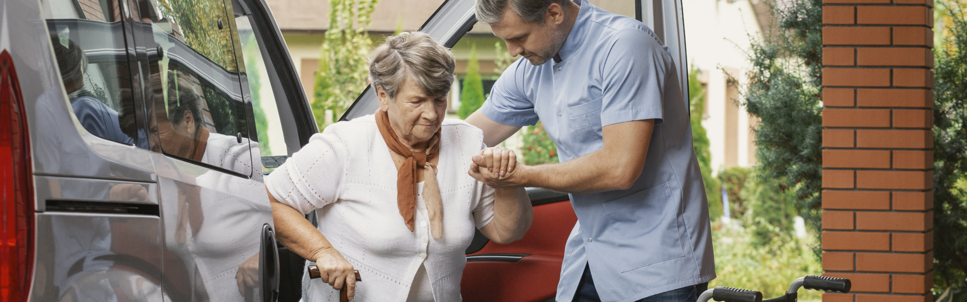 aide assisting the senior woman to walk