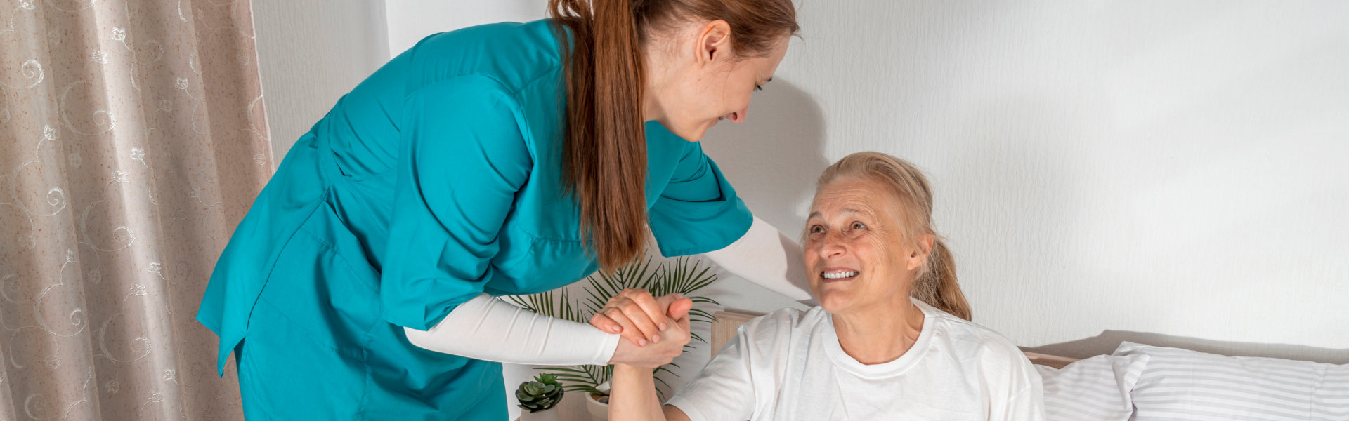 aide smiling while taking care of the senior woman