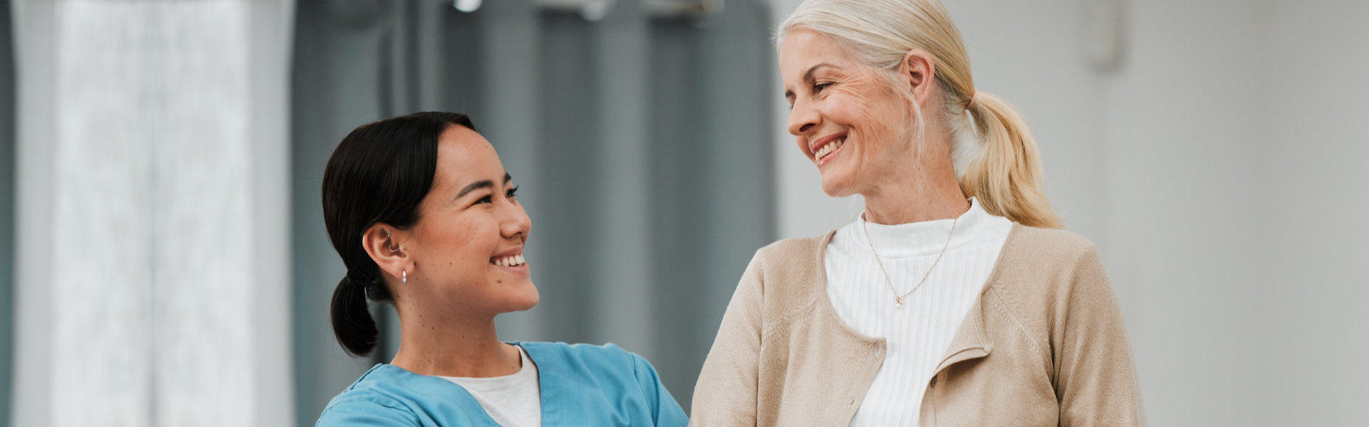 aide and senior woman smiling at each other