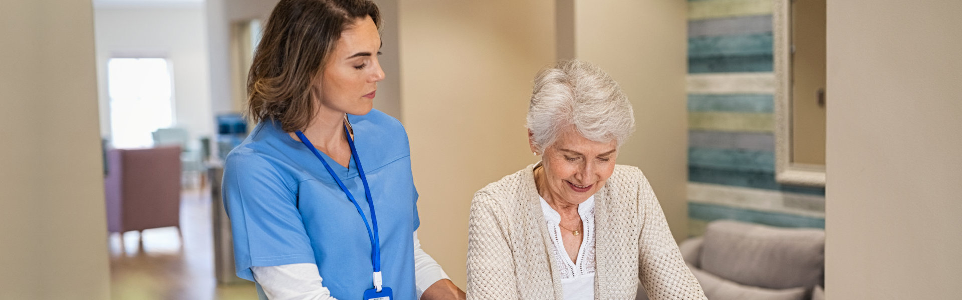 aide assisting the senior woman to walk