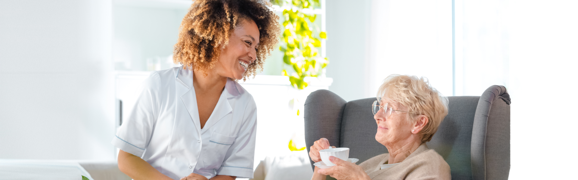 A woman sits in a chair beside an older woman